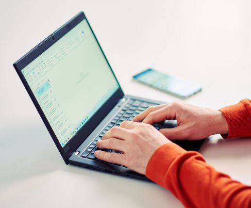 Hände einer Person beim Arbeiten am Laptop